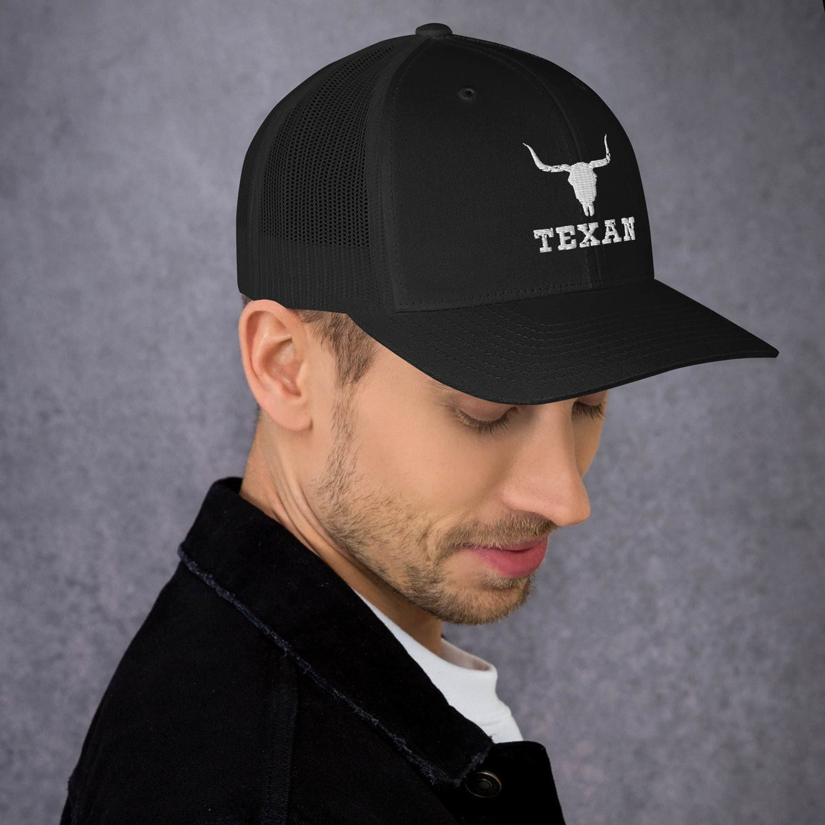 Black trucker hat with white bull head and “TEXAN” text on the front panel.