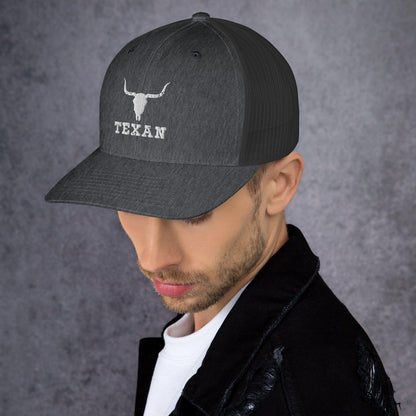 Charcoal gray trucker hat with mesh back and white bull and “TEXAN” patch on front
