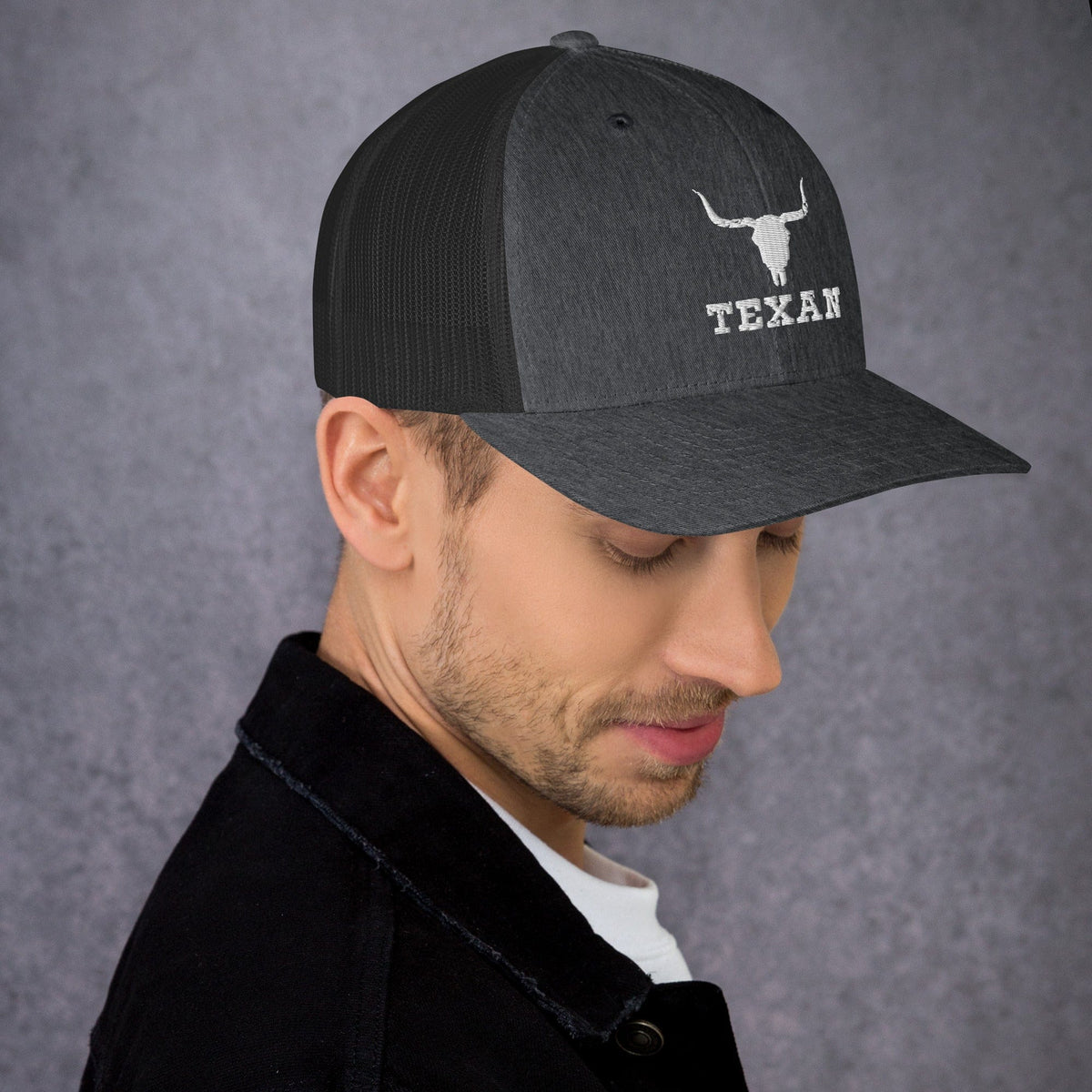 Dark gray trucker hat with mesh back and white bull and “TEXAN” patch on front panel