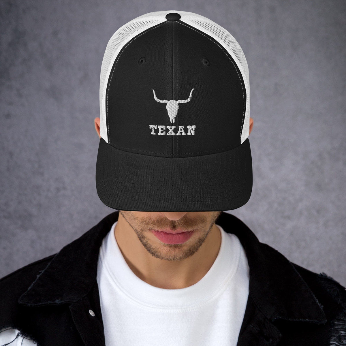 Black trucker hat with white mesh back, white bull head, and “TEXAN” front lettering.