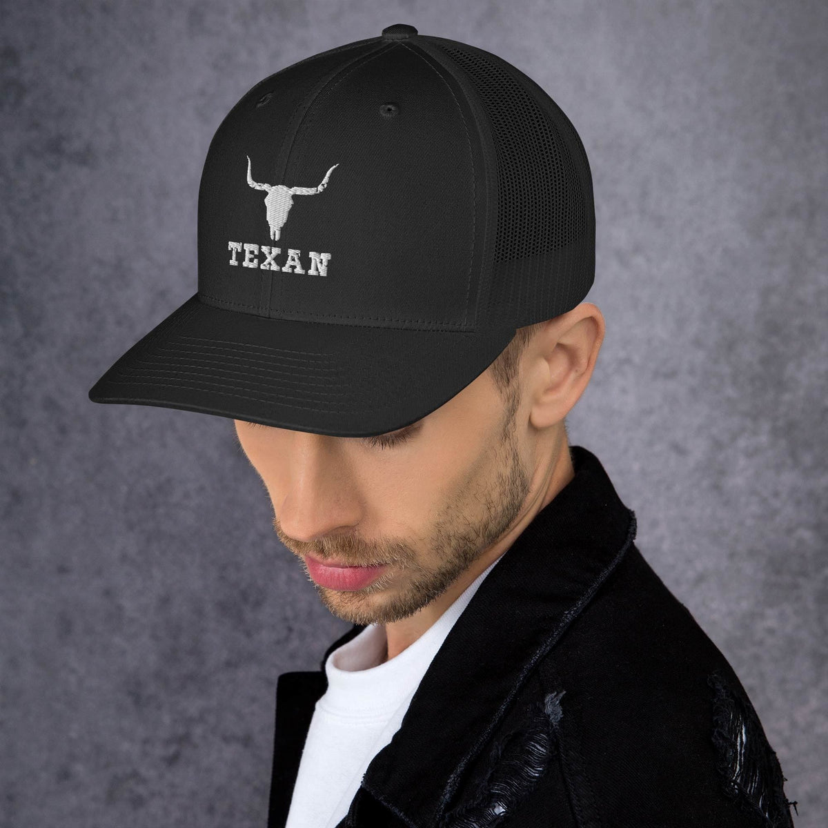 Black trucker hat with white bull outline and TEXAN logo, side profile