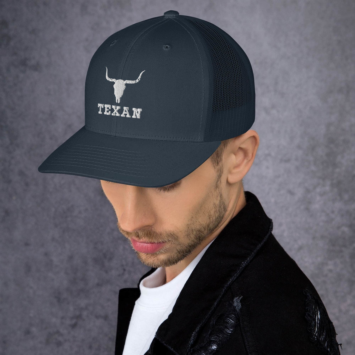 Dark navy trucker hat with white bull head and “TEXAN” text, side view.