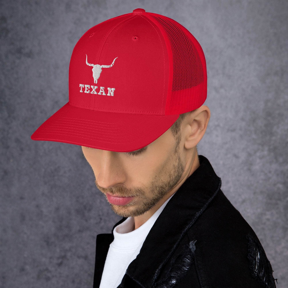 Red trucker hat with mesh back and white bull and “TEXAN” patch on front panel