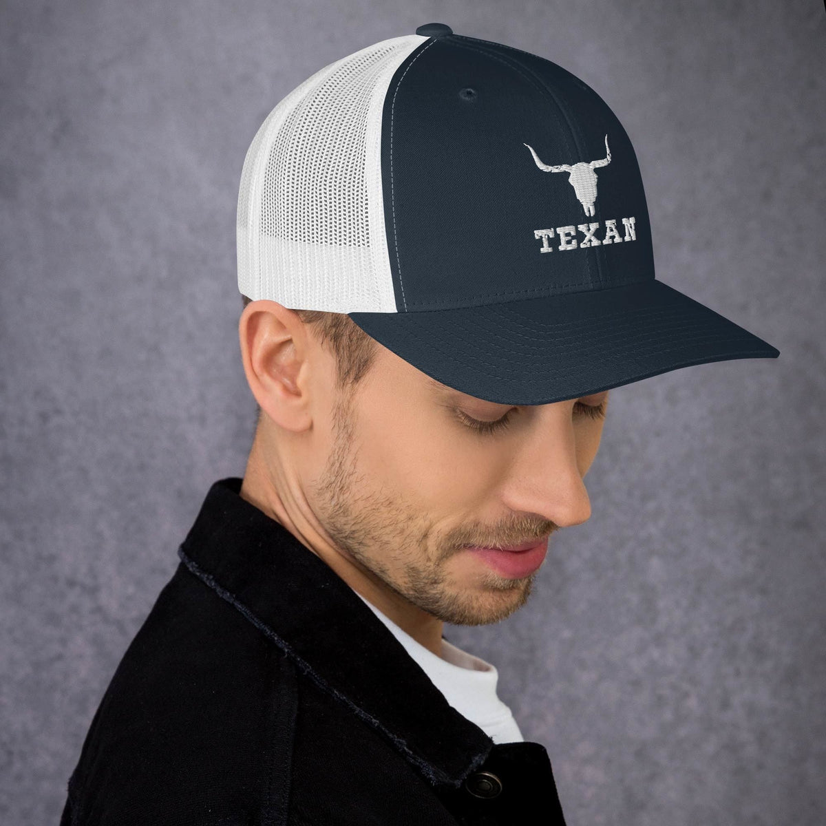 Black and white mesh trucker hat with white bull head icon and “TEXAN” on the front.