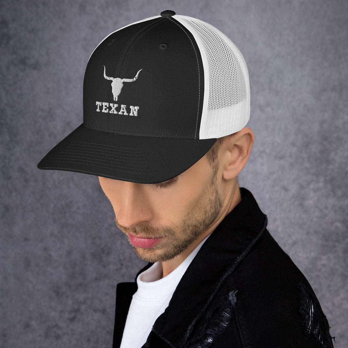 Black front trucker hat with white mesh side panels, white bull head, and “TEXAN” text.