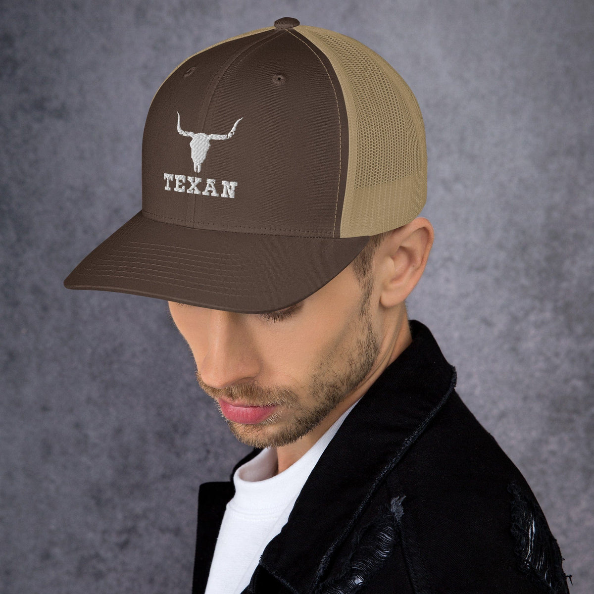 Brown trucker hat with mesh back and white bull and “TEXAN” patch on front panel