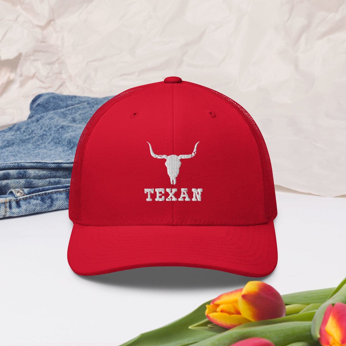 Red trucker hat with white bull outline and TEXAN logo on front