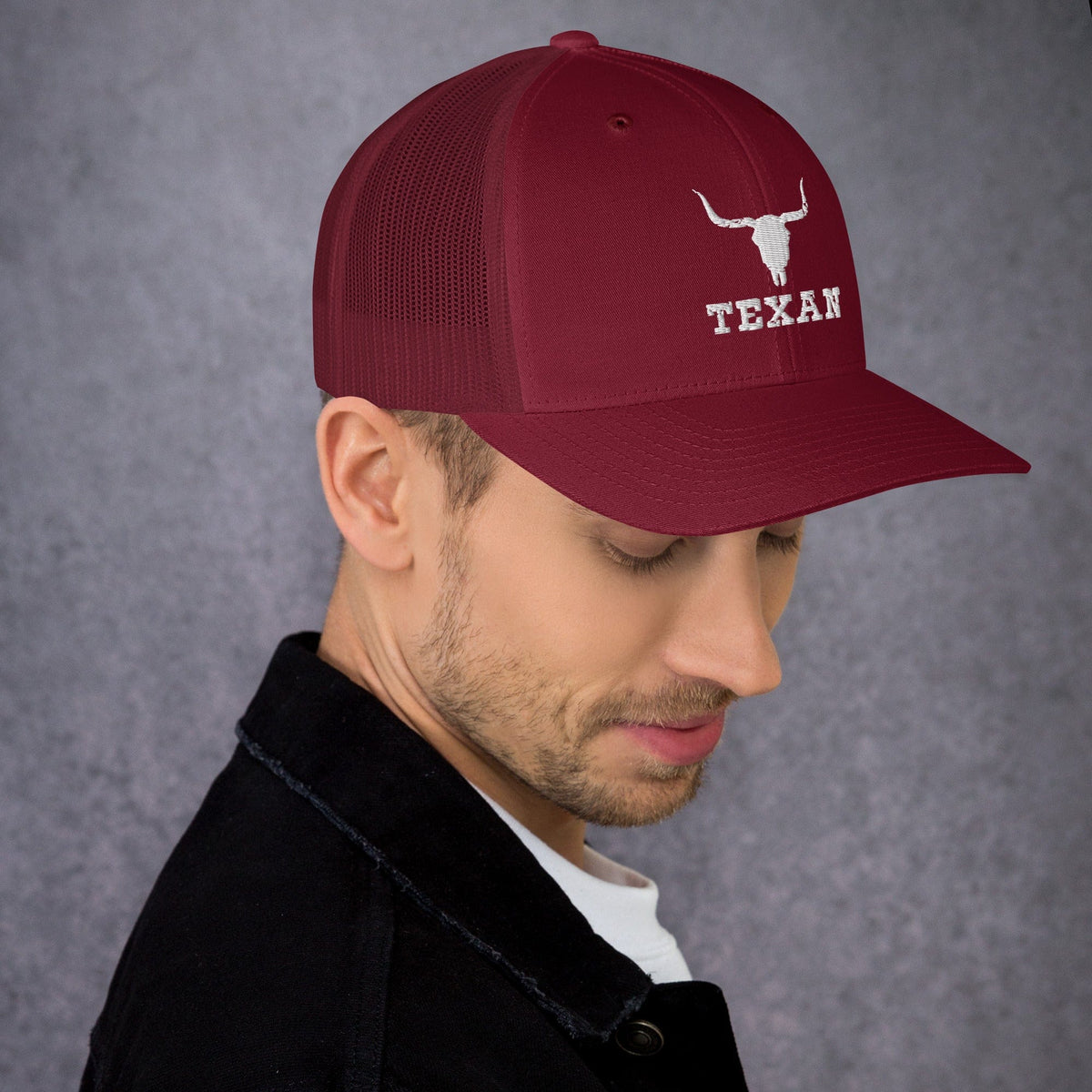 Burgundy trucker hat with mesh back and white bull and “TEXAN” patch on front panel