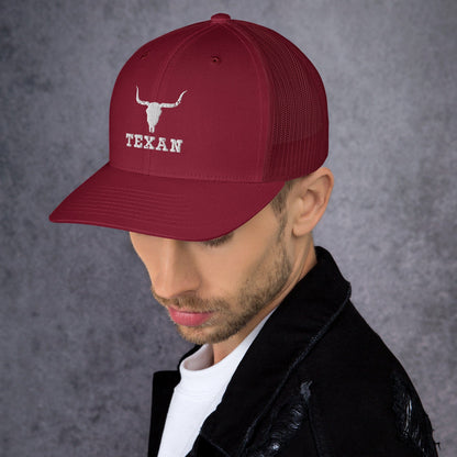 Burgundy trucker hat with mesh back and white bull and “TEXAN” patch on front panel