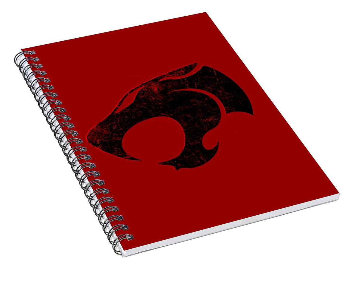 Spiral notebook with red cover and large distressed black Thundercats logo, angled
