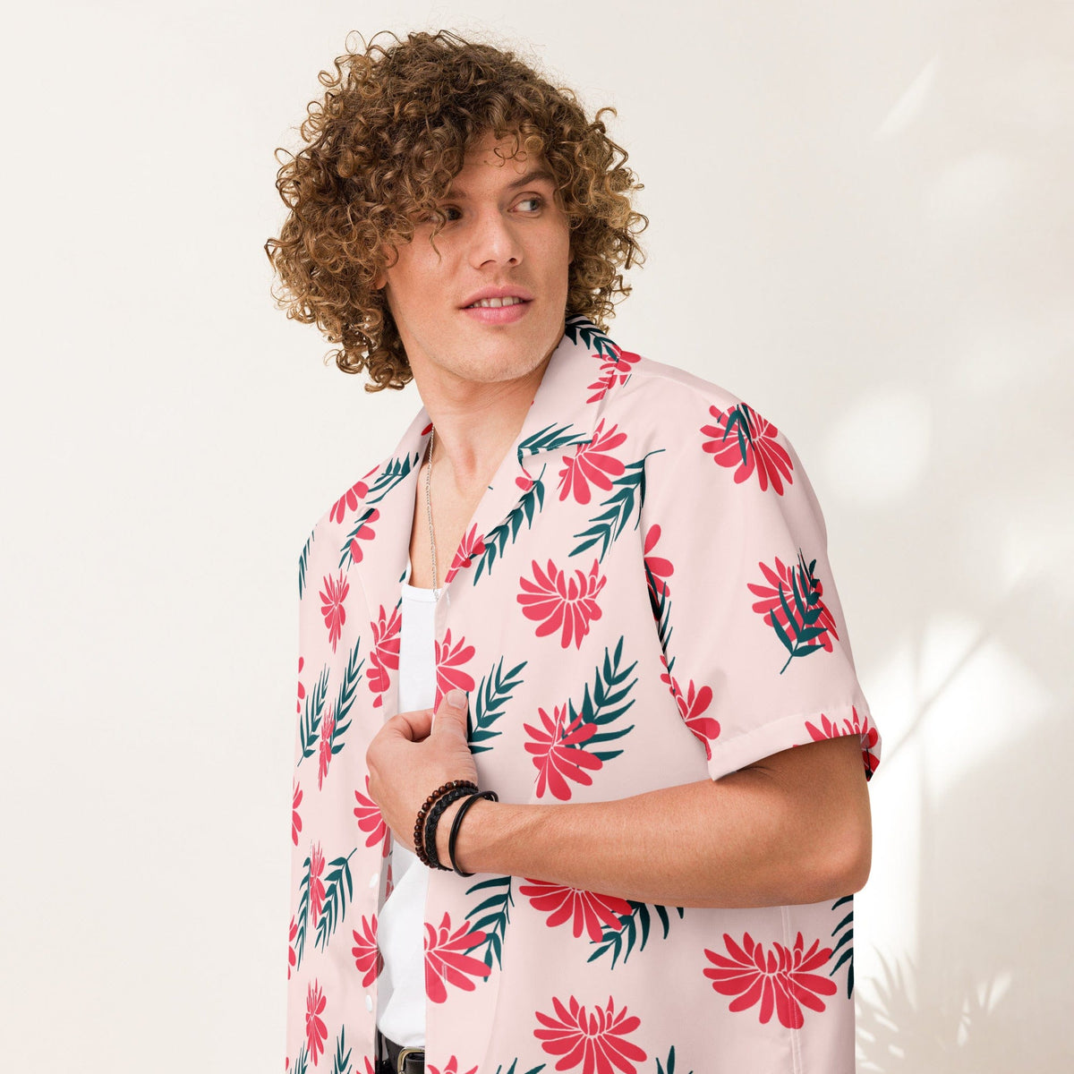 Light pink short-sleeve tropical shirt with red flowers, green leaves, and open collar.