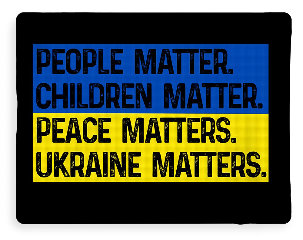 Black blanket with blue and yellow slogan print: CHILDREN MATTER, PEACE MATTERS