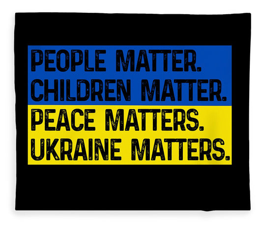 Black blanket with blue and yellow slogan print: PEOPLE MATTER, PEACE MATTERS