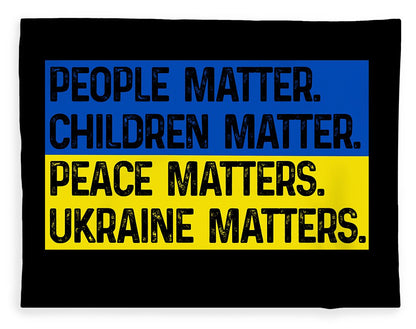 Black blanket with blue and yellow slogan print: PEOPLE MATTER, CHILDREN MATTER