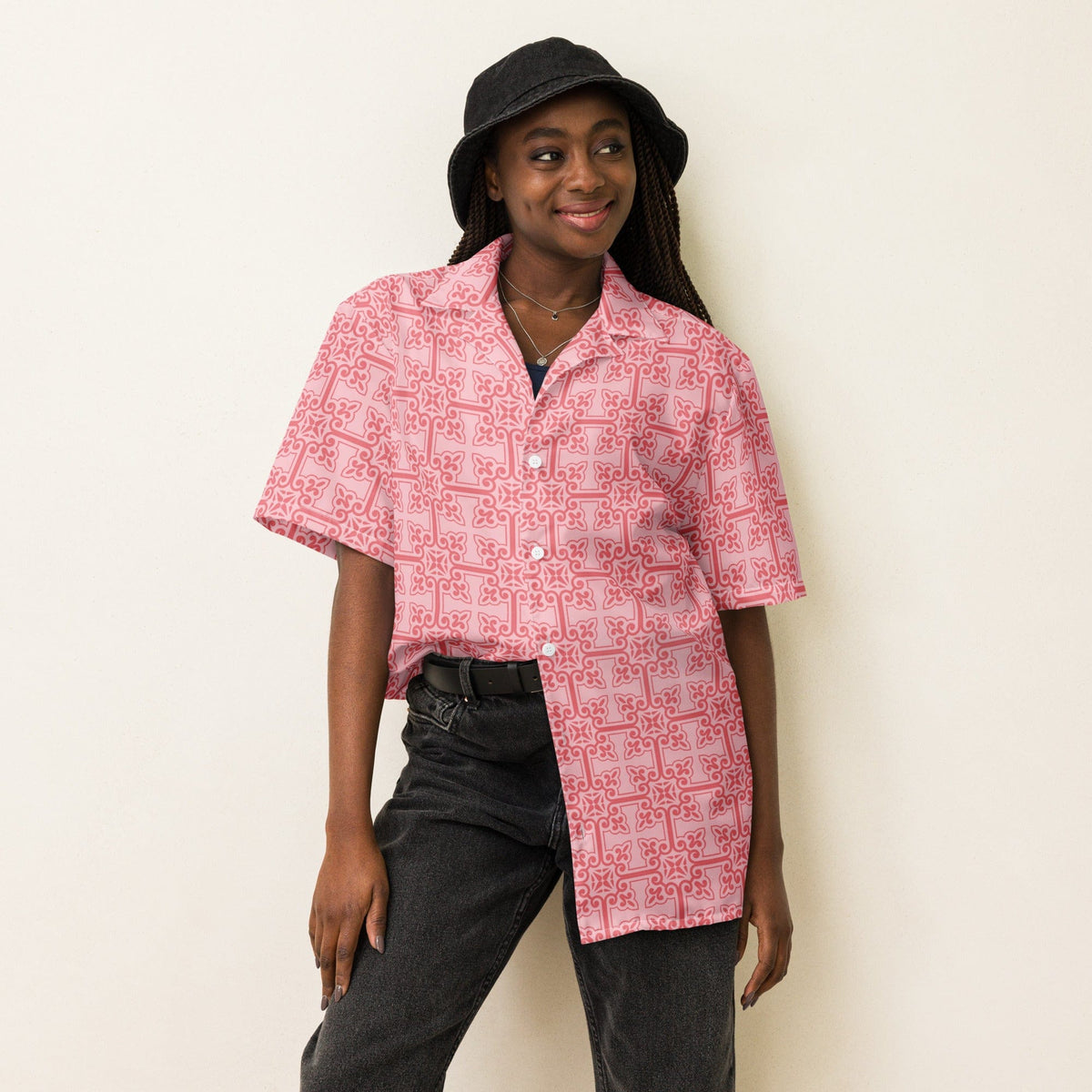 Pink patterned button-up shirt on model, short sleeves and open collar.