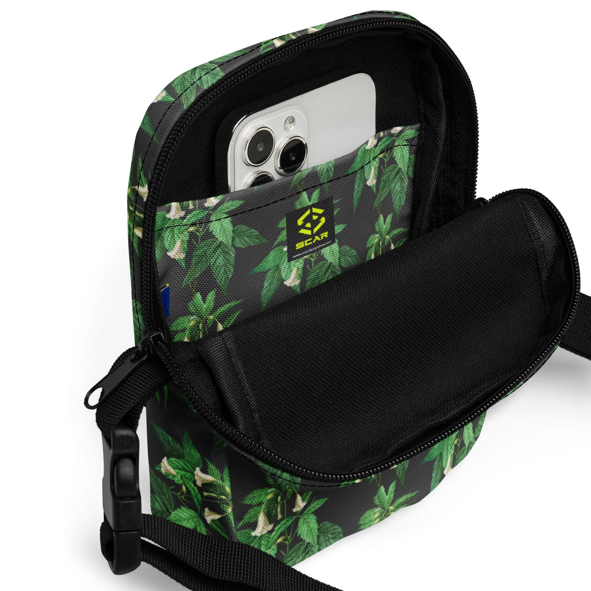 Utility crossbody bag with green leaf floral print, open top shows phone pocket
