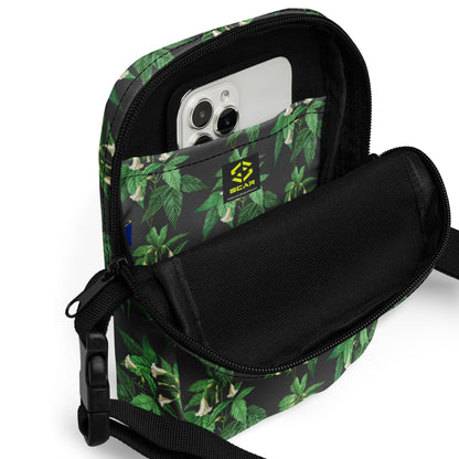 Utility crossbody bag with green leaf floral print, open top shows phone pocket