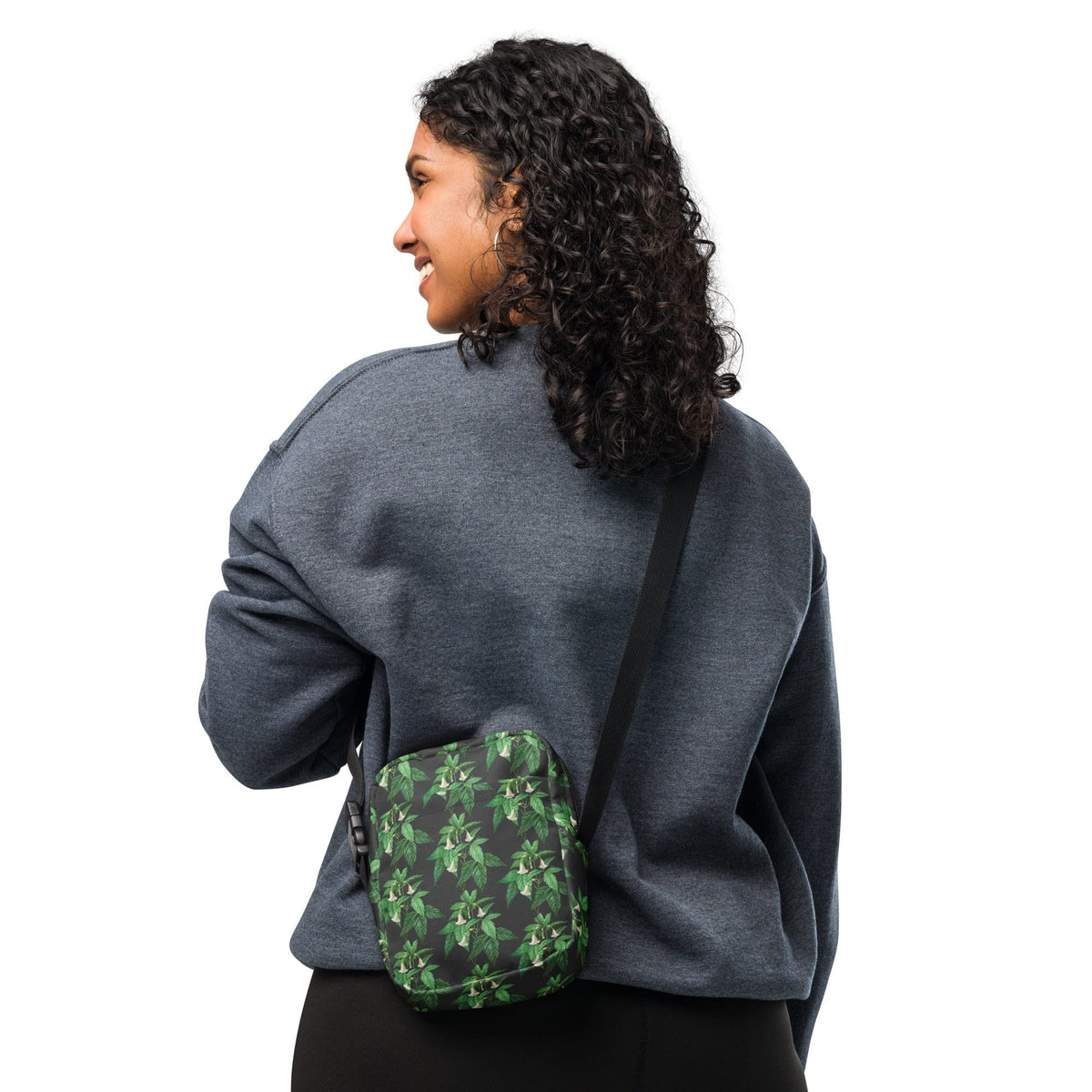 Utility crossbody bag on model, green floral print, black strap and zip closure