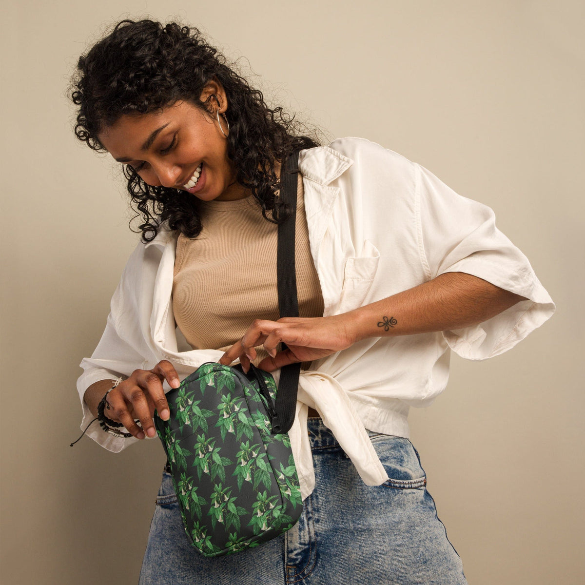 Utility crossbody bag worn cross-body with green leaf floral print and top opening